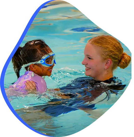 Child practicing one-on-one swim lesson with instructor at FINS Swim School.

