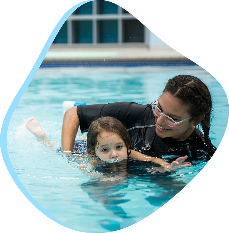 An adult student practices breath control and stroke technique during a private swim lesson at FINS Swim School.