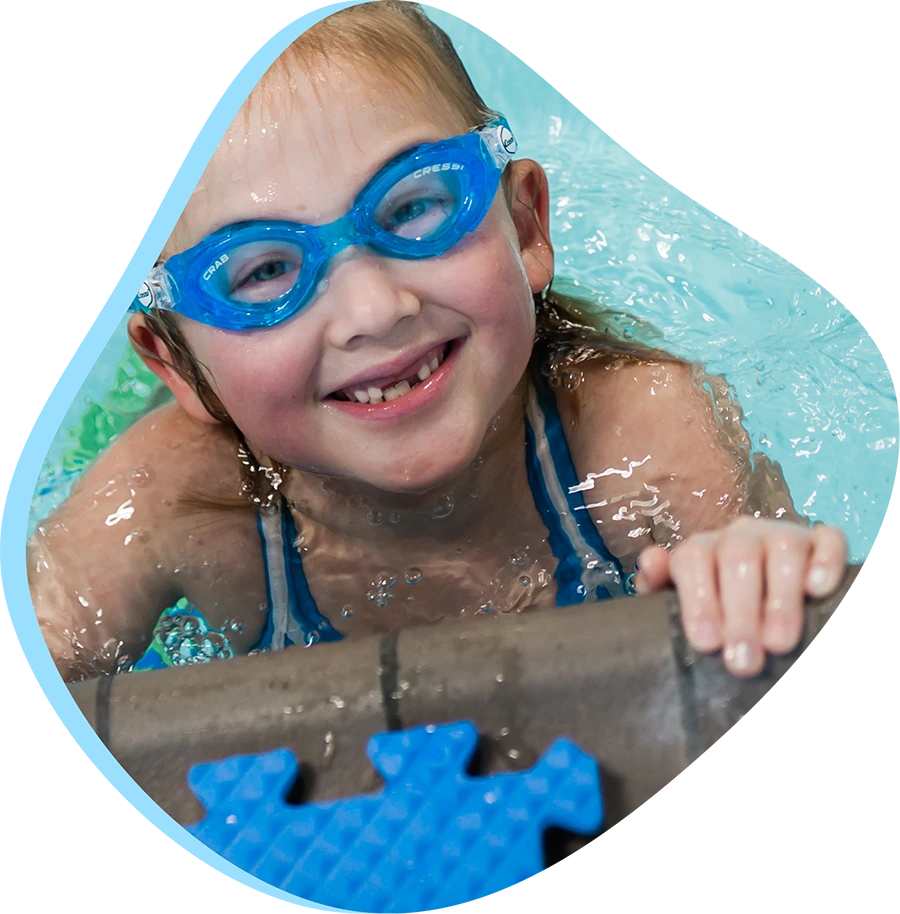 A FINS swim instructor guiding a child during a swim lesson.