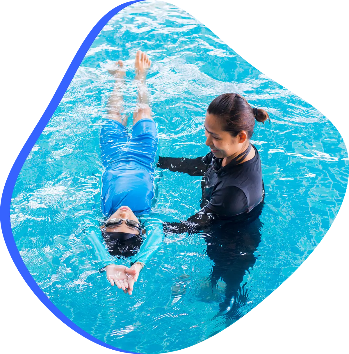Swim instructor teaching a child during a focused one-on-one lesson in an indoor pool.