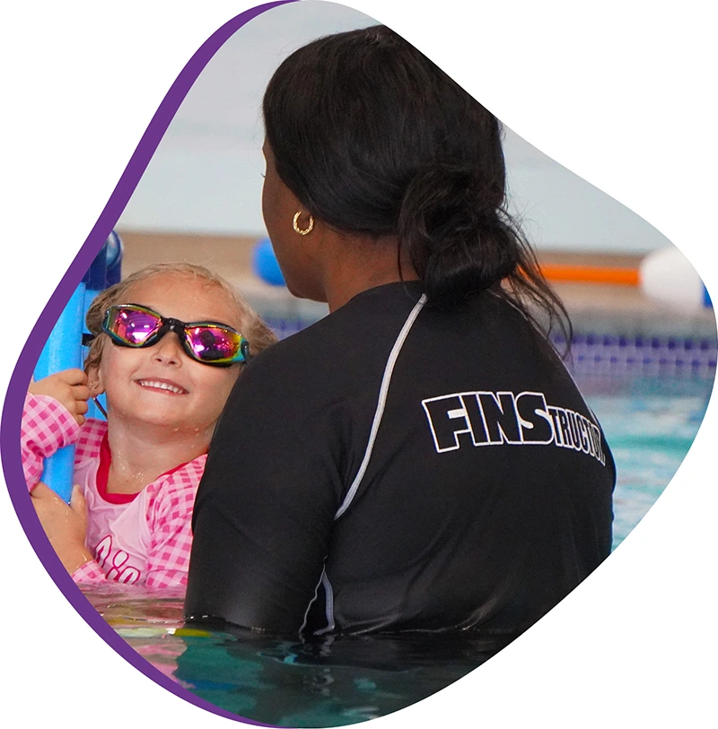 A child practicing competitive stroke technique during a private swim lesson at FINS Swim School.