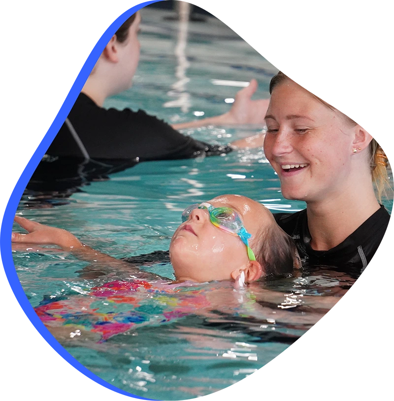 A child practicing competitive stroke technique during a private swim lesson at FINS Swim School.