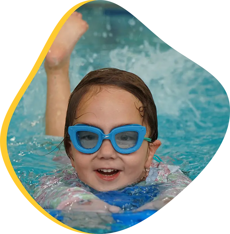 A young swimmer practicing freestyle stroke during a private one-on-one swim lesson at FINS Cypress.