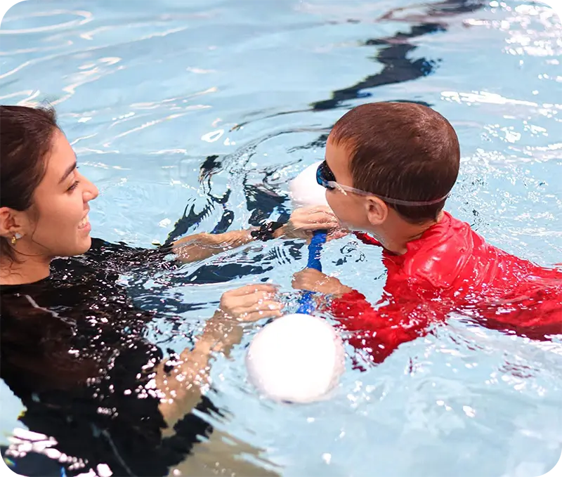 A student and instructor practicing swim techniques in The Woodlands, TX, indoor facility.