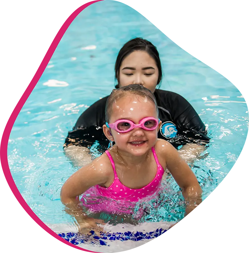 Parent and infant participating in a guided swim lesson with a finstructor at the FINS Fleet indoor pool.