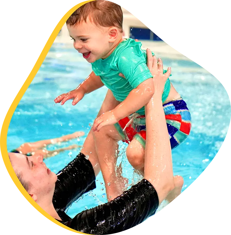 Parent and infant participating in a guided swim lesson with a finstructor at the FINS Fleet indoor pool.