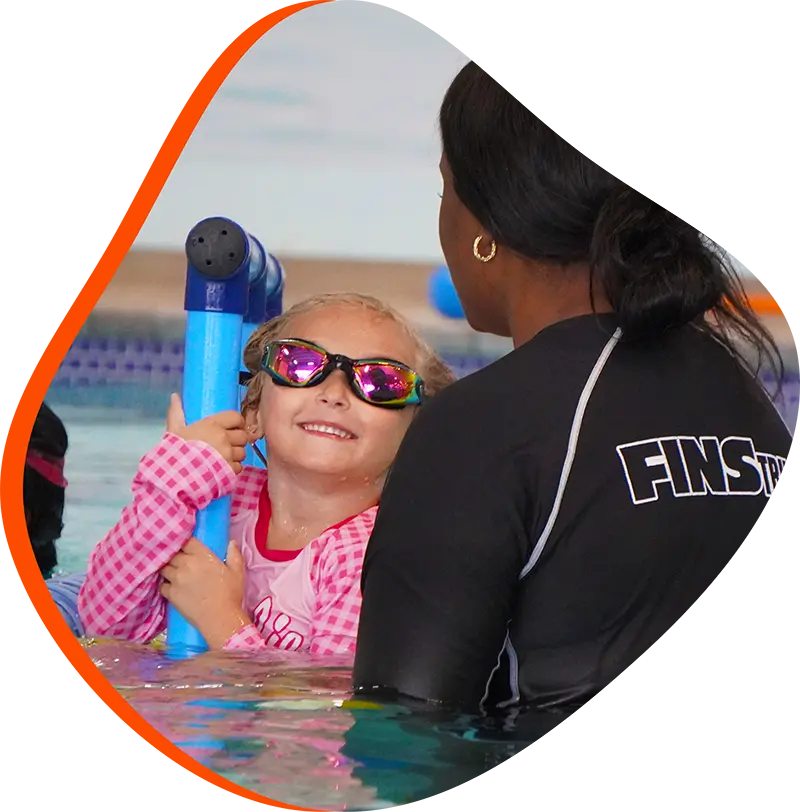 A young swimmer practicing freestyle stroke during a private one-on-one swim lesson at FINS Fleet.