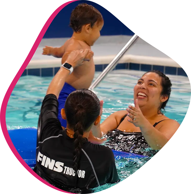 Professional FINS instructor teaching a one-on-one private swim lesson in a climate-controlled indoor pool.