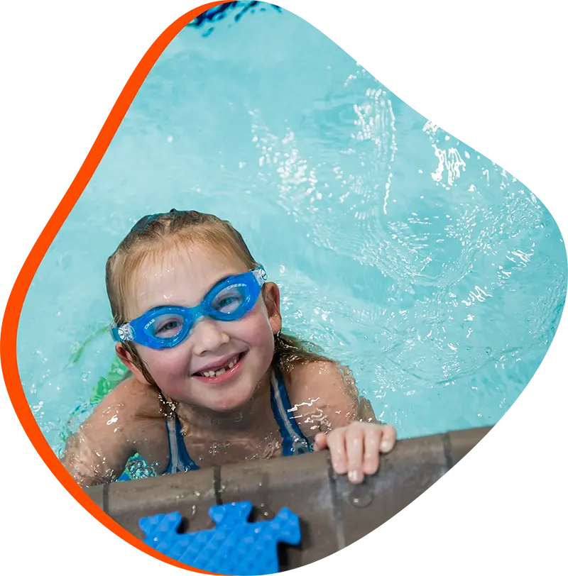 Young swimmer practicing freestyle technique during a private swim lesson at FINS Spring indoor pool.