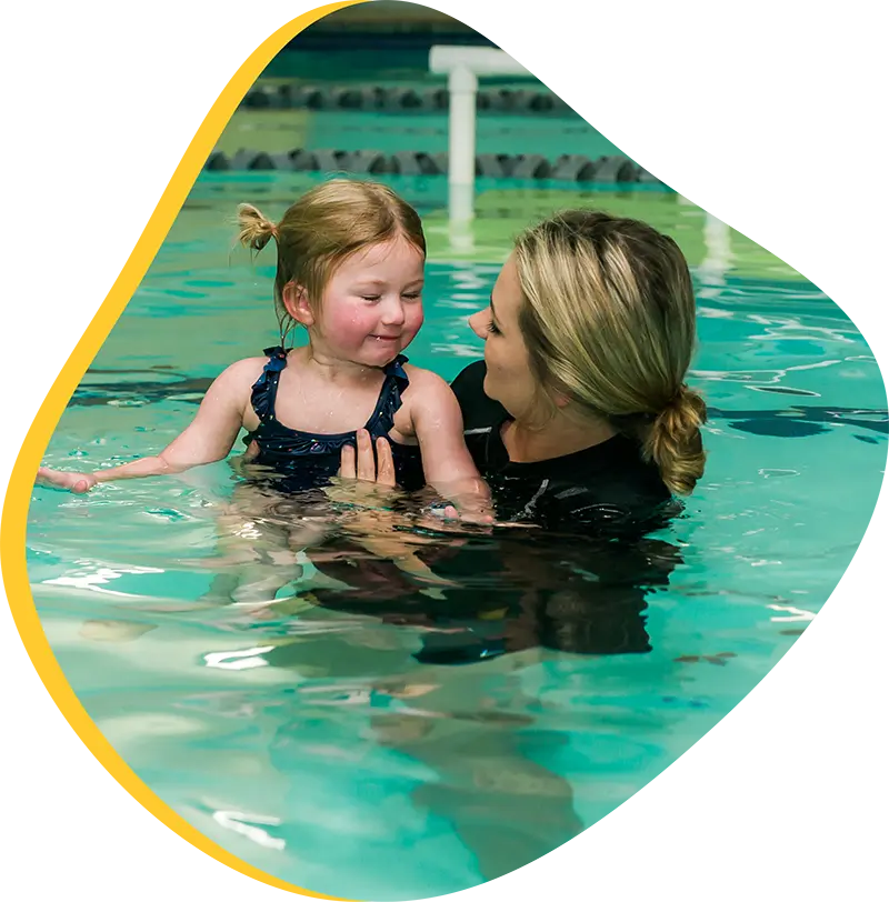 Young swimmer practicing freestyle technique during a private swim lesson at FINS Spring indoor pool.