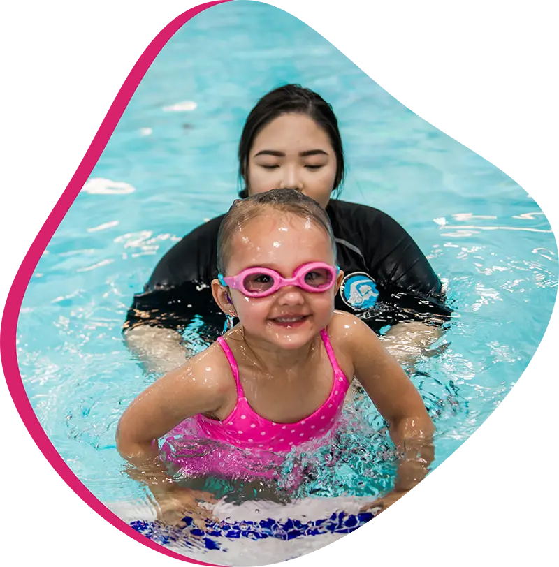 Swim instructor teaching one-on-one swim lesson at FINS.