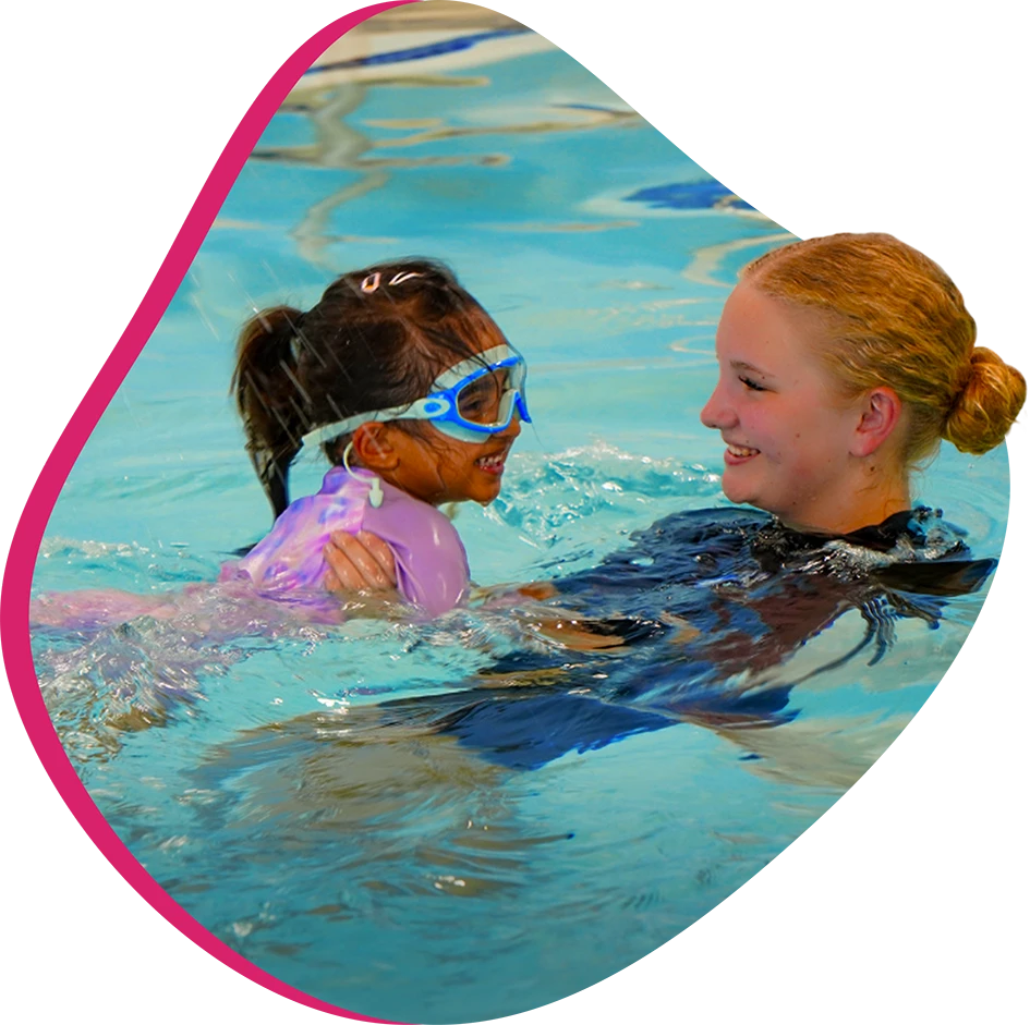 A student and instructor practicing swim techniques in The Woodlands, TX, indoor facility.